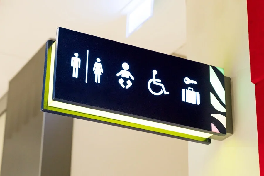 An illuminated sign with pictograms for bathroom facilities.